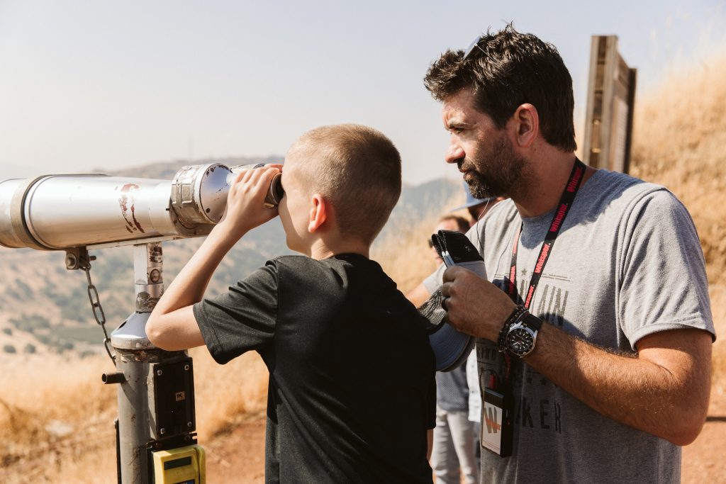 aaron shust and son looking through telescope