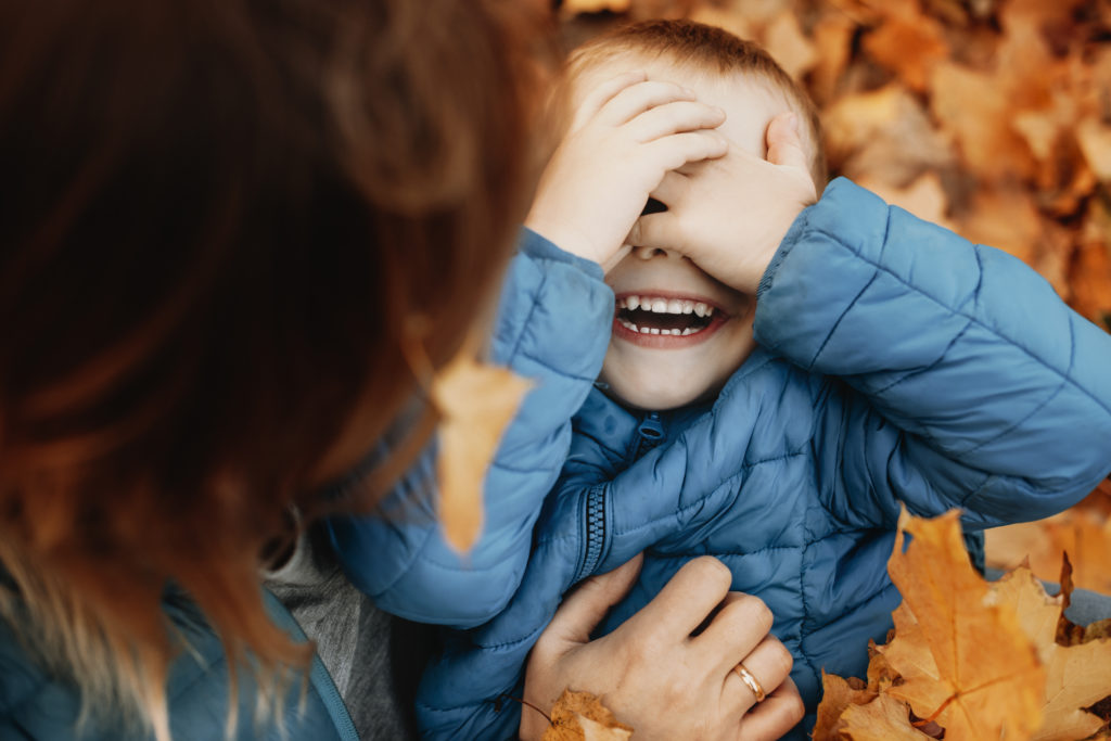 kids laughing covering his face with his hands