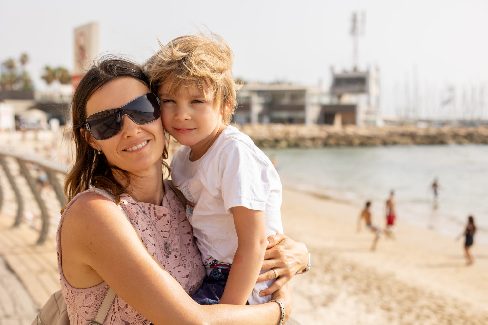 Mother and child, family enjoying the seaside views in Tel Aviv on a hot summer day, afternoon