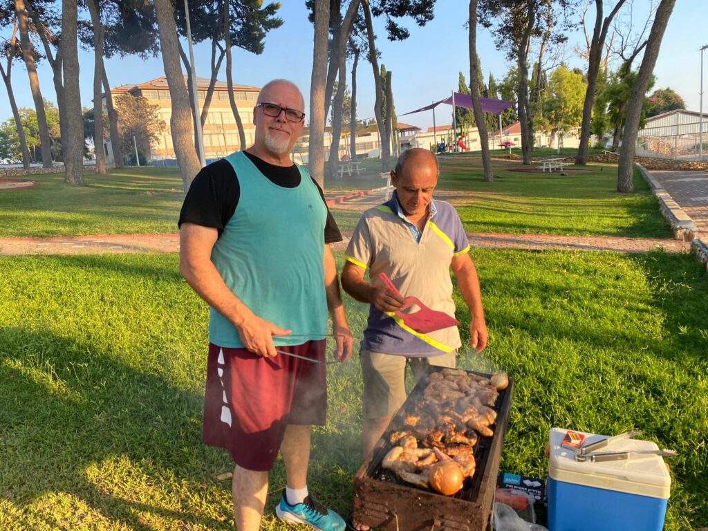 two people standing at a grill