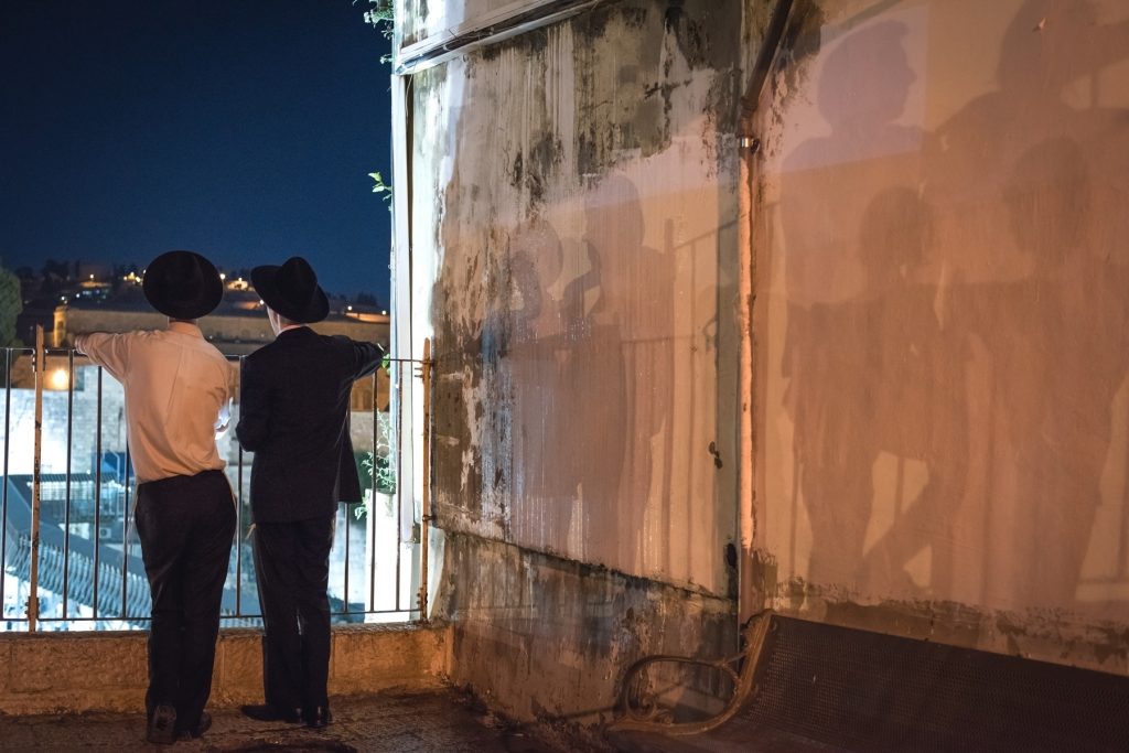 two jewish men looking at the western wall