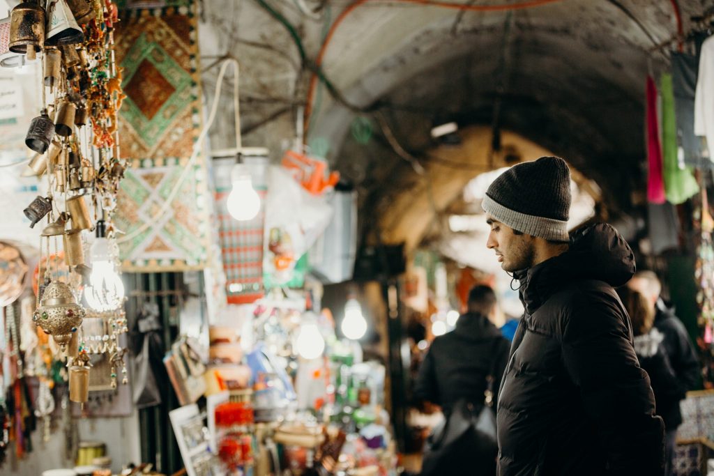 man standing in a colorful market in israel