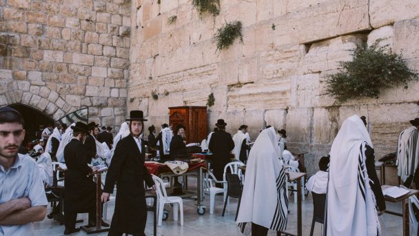men praying at the western wall