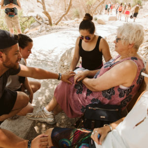 group of people blessing an older woman