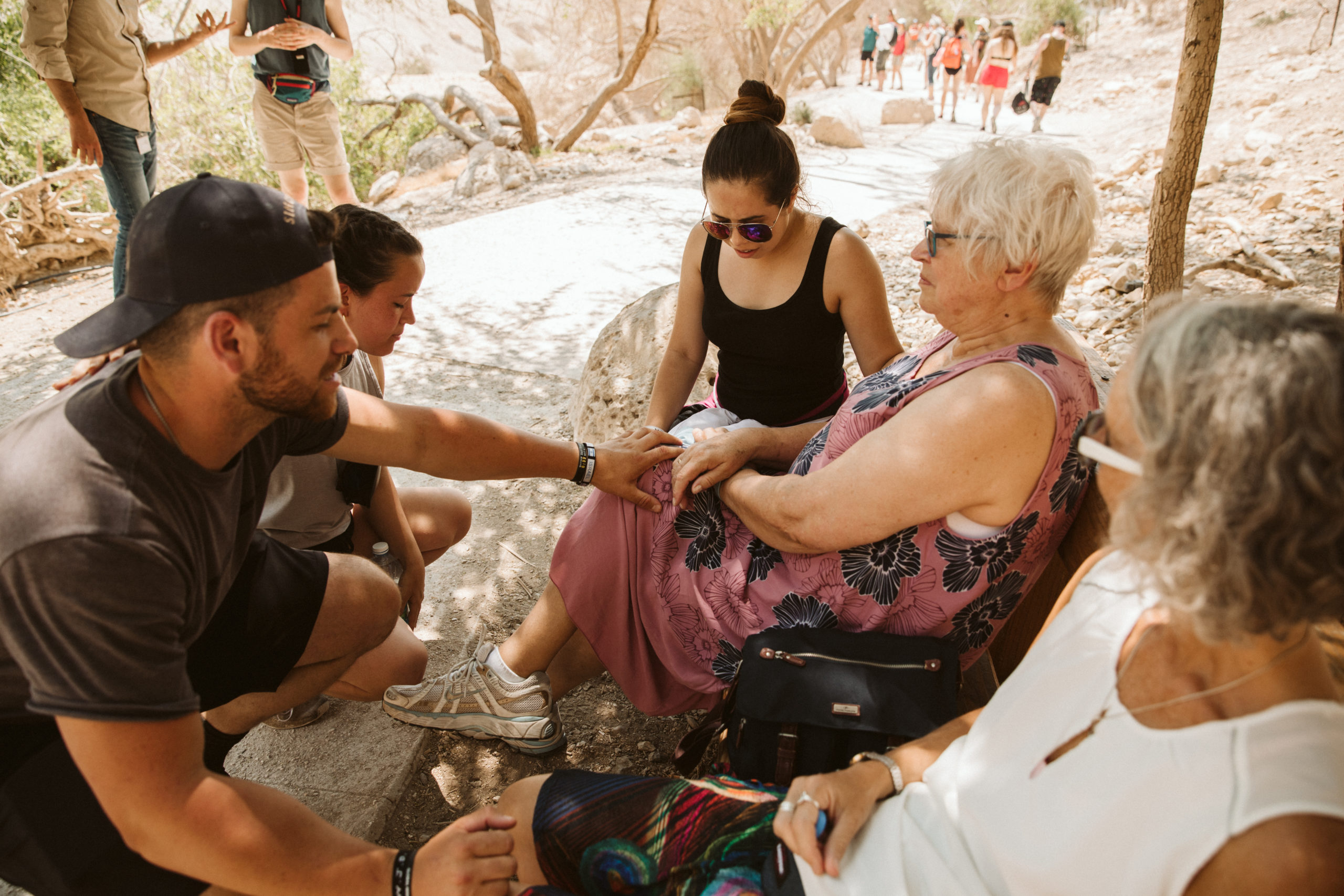 group of people blessing an older woman