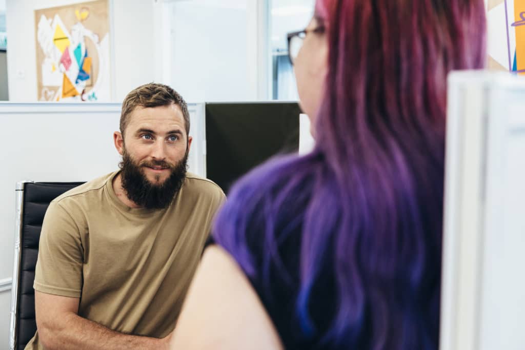 young man talking to a girl with purple hair