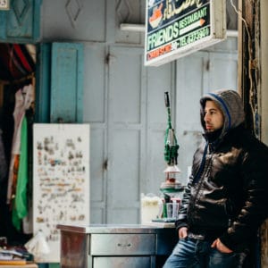 man leaning against a wall in an old city market