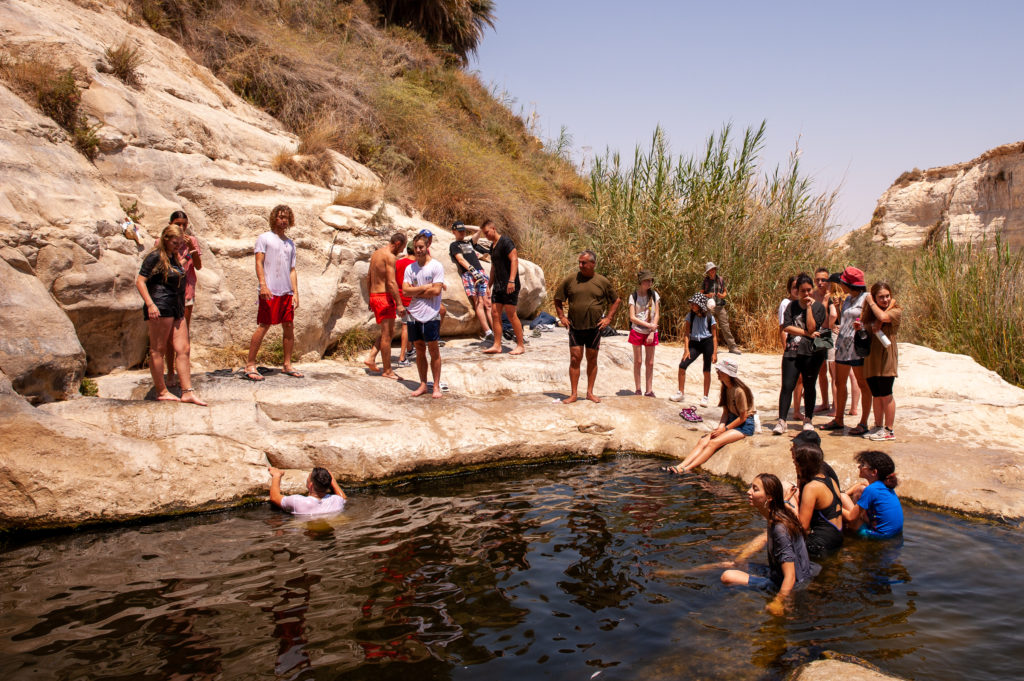a bunch of kids at a watering hole